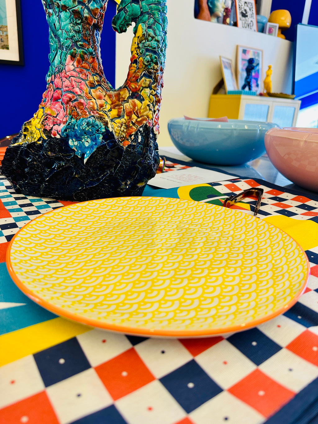 Assiette jaune et blanche à motif avec bordure orange.
